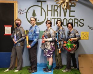 the five members of the Bone Guard Books foam blaster tag team pose with their favorite blasters at the Thrive Outdoors leadership center